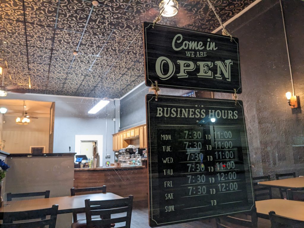 open sign in a window with coffee bar in the background